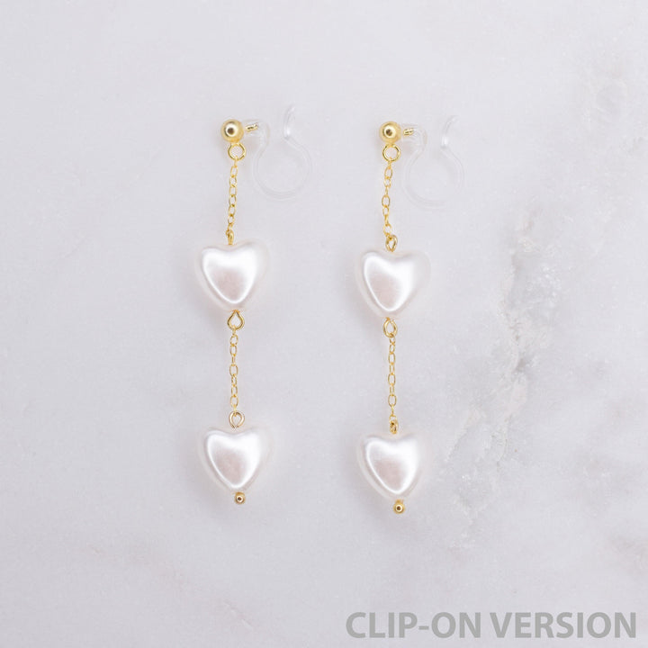 Heart shaped pearl dangle clip on earrings in gold with invisible clear comfortable hypoallergenic resin clip