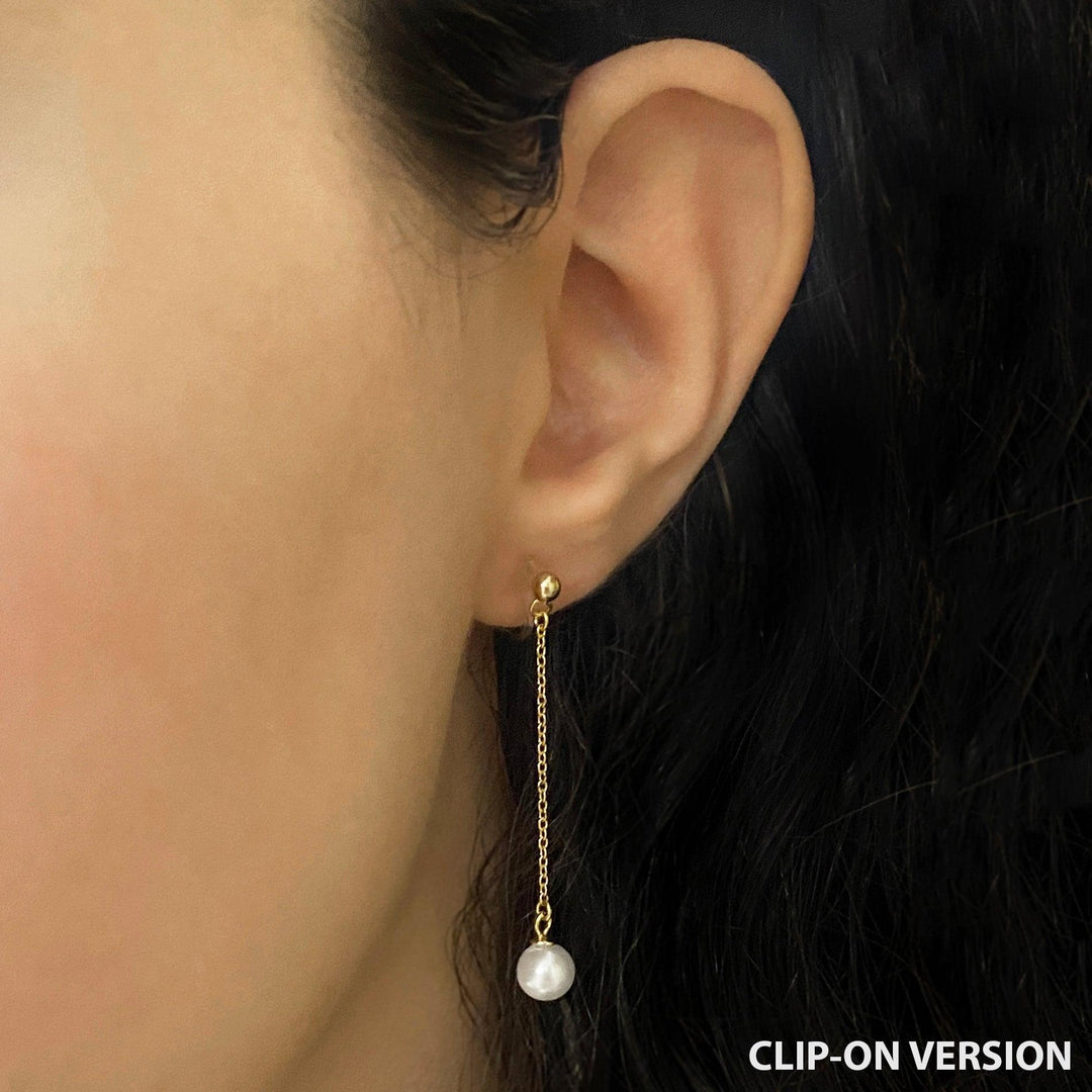Dainty pearl dangle clip on earrings in gold worn on ear