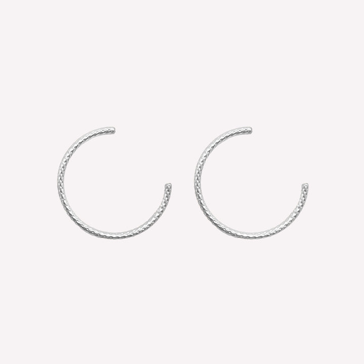 Thin medium size textured hoop clip on earrings in silver