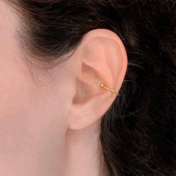Twist ear cuff clip on earring in gold on the ear as a fake conch cartilage piercing