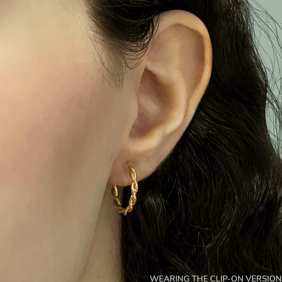 Twist huggie hoop clip on earrings in gold worn on ear