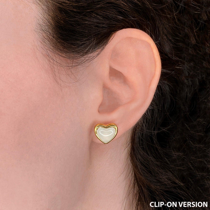 White heart stud clip on earrings in gold worn on ear